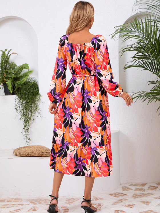 Back view of the Printed Long Sleeve Midi Dress showcasing its vibrant prints, tied waist, and off-shoulder neckline.