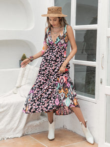  Woman wearing a Printed Plunge Sleeveless Midi Dress featuring bold floral and ikat patterns, tied waist, and sleeveless design, perfect for casual outings.