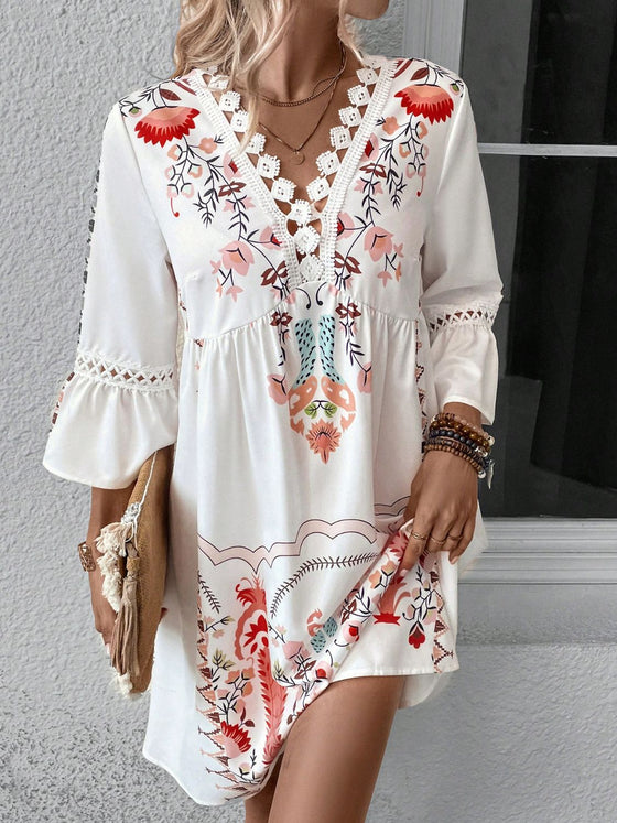 Model wearing the off-white printed dress in a front-facing pose, highlighting the soft palette and flowy elegance of the material.

