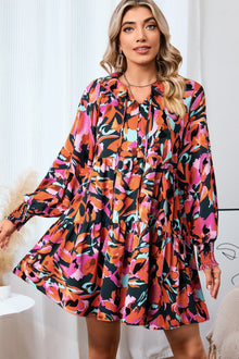  Woman wearing a Printed Tie Neck Lantern Sleeve Mini Dress, featuring vibrant floral patterns and elegant lantern sleeves, perfect for casual and semi-formal occasions.