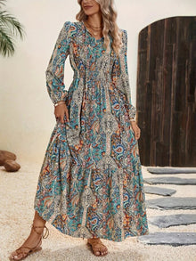  Model wearing a Printed Tie Neck Long Sleeve Maxi Dress with a paisley print, featuring a tie neckline and flowy silhouette, perfect for boho-inspired casual or semi-formal occasions.