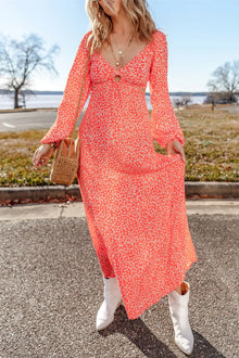  Woman wearing a vibrant floral Printed V-Neck Long Sleeve Midi Dress with a cutout detail, styled with white boots for a chic, daytime look.