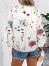 A white blouse styled from the back, highlighting the soft printed fabric and subtle rear silhouette.
