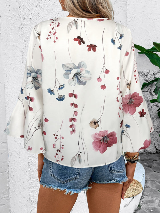 A white blouse styled from the back, highlighting the soft printed fabric and subtle rear silhouette.