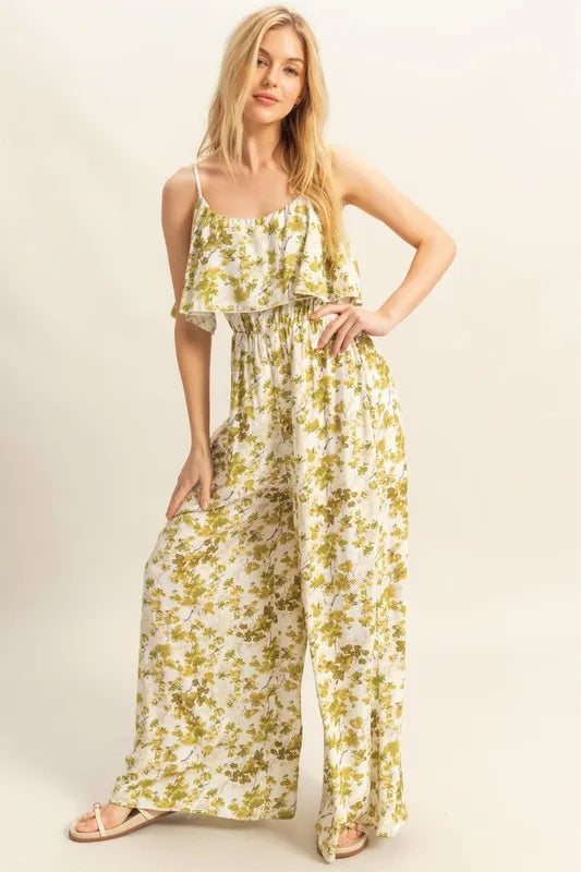 Full front image highlighting the bold print and flowy wide-leg design of the yellow-green jumpsuit, styled for daytime chic or vacation wear.