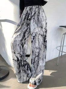  Stylish printed wide-leg pants in black-and-white abstract pattern, featuring an elastic waistband and flowy silhouette, perfect for casual outings or events.

