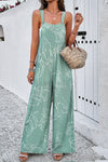 Model wearing the Printed Wide Strap Jumpsuit styled with beach accessories, ideal for a relaxed summer day.