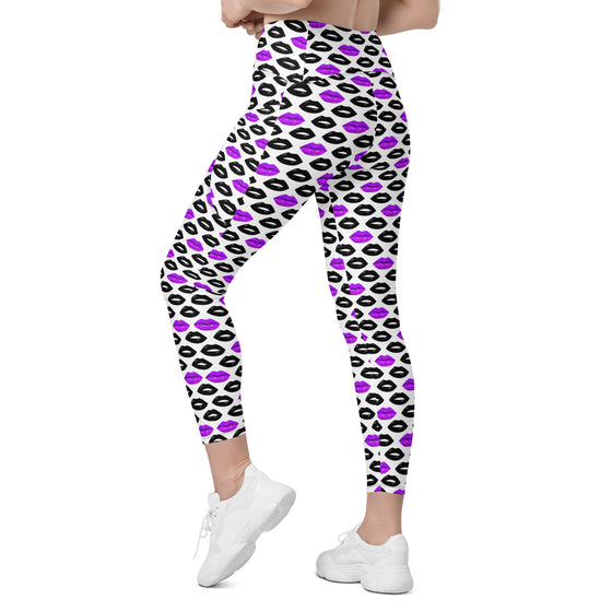 Model walking in white leggings with pop-art lips print in purple and black. High waist compression leggings for women with pockets and sculpted fit.
