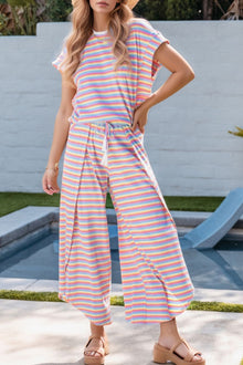  Model wearing the purple colorful striped lounge set from the front, showcasing a relaxed-fit top and comfy drawstring shorts perfect for casual days.