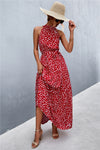 Front view of red printed tie waist maxi dress with bold, bright floral-inspired details—standout style for outdoor and vacation settings.