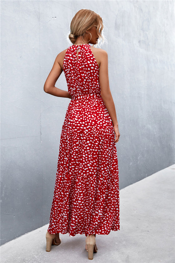 Back view of red sleeveless printed maxi dress with a flowing hem—classic and eye-catching choice for weekend plans or getaways.