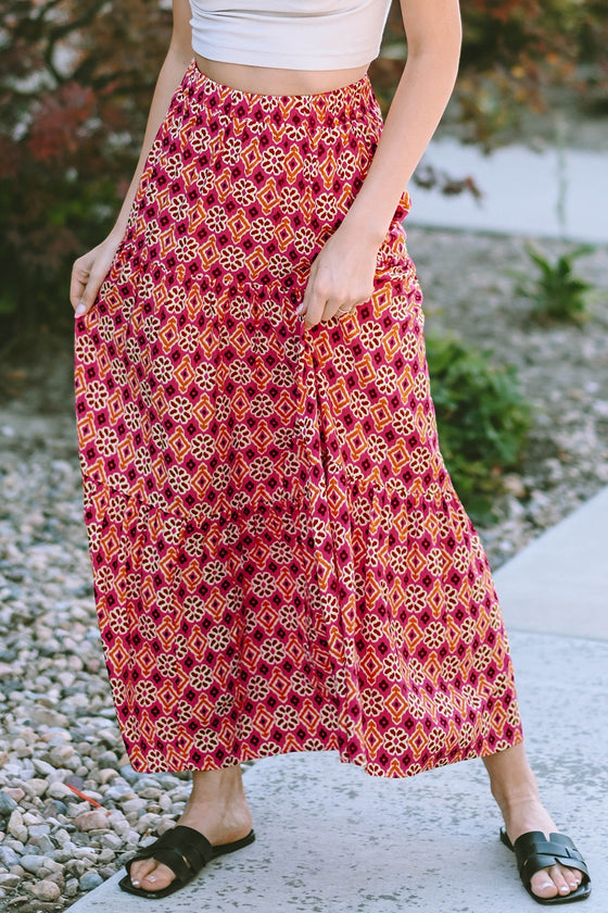Alternate front view showing the flowing silhouette and rose pattern of the tiered maxi skirt.