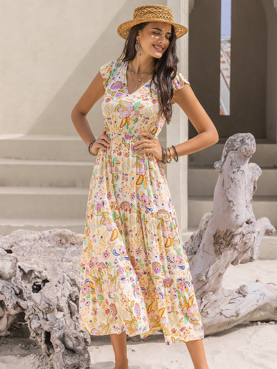 Model wearing the Ruched Printed Cap Sleeve Midi Dress styled with boho accessories, perfect for a summer day.