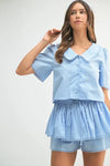  Stylish front pose of the crop set highlighting the soft blue color and flattering fit of the short-sleeve top and matching bottoms.