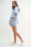 Trendy side view of the outfit set styled in sky blue, highlighting the layered hem and playful profile.