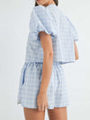 Back view highlighting the stylish silhouette of the sky blue set, emphasizing the top's relaxed V-neckline and the well-tailored shorts with a flattering fit.

