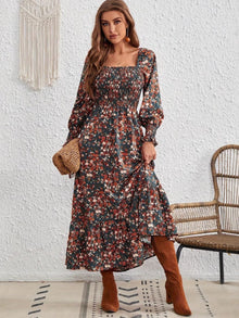  Model wearing a smocked floral square neck dress with long sleeves and a flowing maxi hemline, styled with brown boots for a chic fall look.

