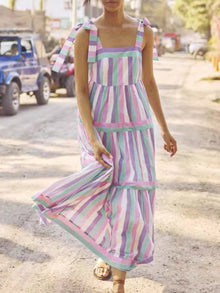  Woman wearing a Square Neck Ruffle A-Line Summer Dress with pastel stripes and tied straps, ideal for casual outings and summer events.

