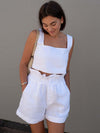 Woman styled in the Square Neck Sleeveless Top and Shorts Set, accessorized with a bucket hat for a relaxed summer vibe