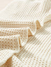 Close-up of tassel detailing on the sleeve and hem of the Tassel Round Neck Top and Shorts Set.