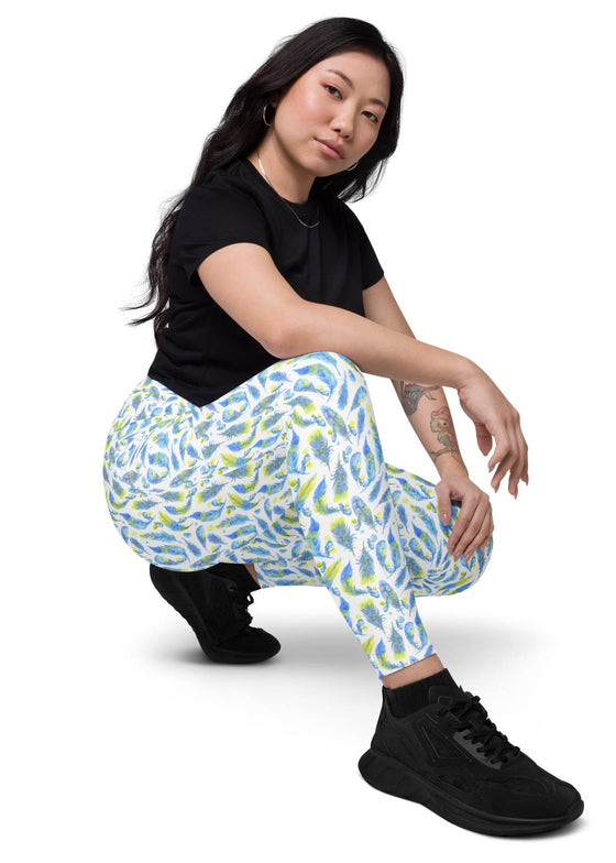 Back view of a woman sitting, wearing Teal Feather Print Compression Leggings for women, highlighting a sculpting high-rise fit with sweat-wicking fabric.