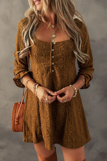  Close-up of a woman wearing a Textured Square Neck Mini Dress in earthy brown tones, styled with layered necklaces and a woven crossbody bag.