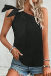 Woman wearing a black textured one-shoulder tank with a tied bow detail, paired with denim shorts and accessories, perfect for casual summer styling.