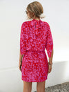 Back view of the Tied Printed Mock Neck Mini Dress showcasing its vibrant print and mini length.