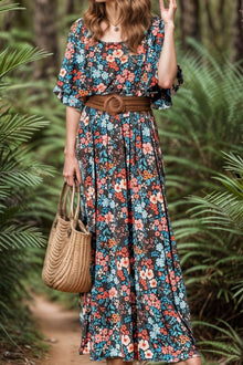  Model wearing a Tied Printed Round Neck Half Sleeve Maxi Dress with a vibrant floral design, featuring a tied waist and flowing skirt, perfect for casual or semi-formal occasions.