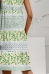 Side view of the Tiered Printed Round Neck Sleeveless Dress, highlighting its flowy silhouette and earthy tones.