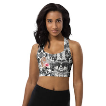  Woman wearing a tiger print high impact racerback sports bra with longline fit. Padded gym bra with maximum support and breathable compression fabric.