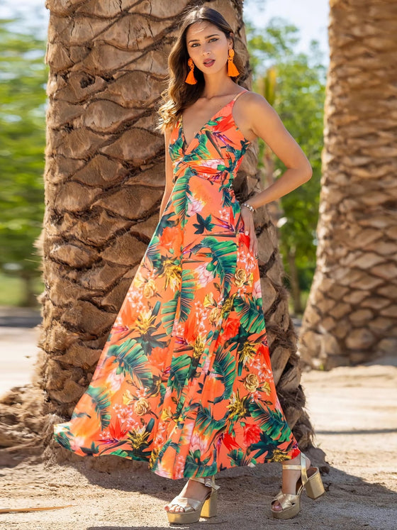 Woman wearing a Twisted Printed V-Neck Cami Dress featuring a bold floral print in orange and purple, with a maxi length and flattering silhouette.

