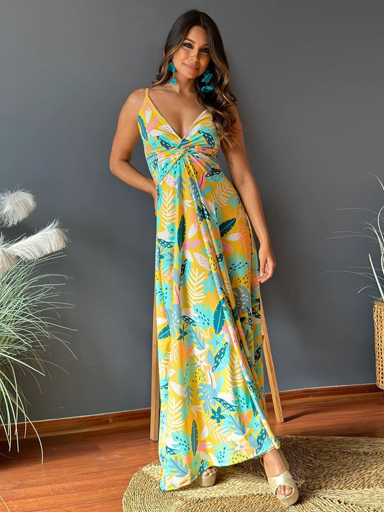 Woman wearing a Twisted Printed V-Neck Cami Dress featuring a bold floral print in orange and purple, with a maxi length and flattering silhouette.

