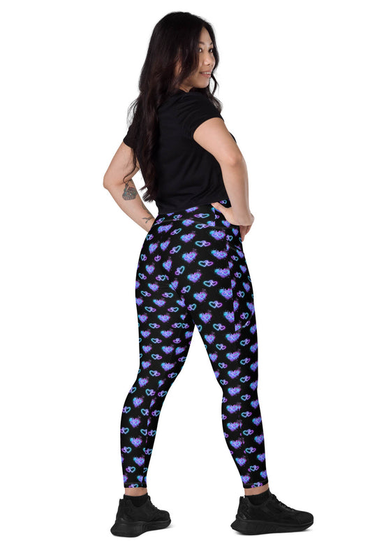 Back view of a woman standing in Vibrant Neon Heart black high-waisted leggings with pockets. Stylish and functional gym leggings for women with a high-rise, compression fit and bold neon heart print.