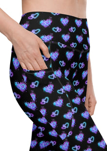  Closeup of Vibrant Neon Heart black high-waisted leggings with pockets, showcasing sleek pocket design and bold neon heart print. Perfect for gym, yoga, or casual wear. High-rise compression leggings for women with functional pockets.