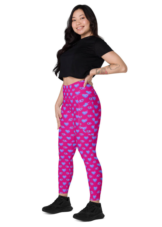 Woman sitting while wearing Vibrant Neon Heart violet-red high-waisted leggings with pockets, side view. Comfortable and stylish workout leggings for women with a tapered fit and bold neon heart print.