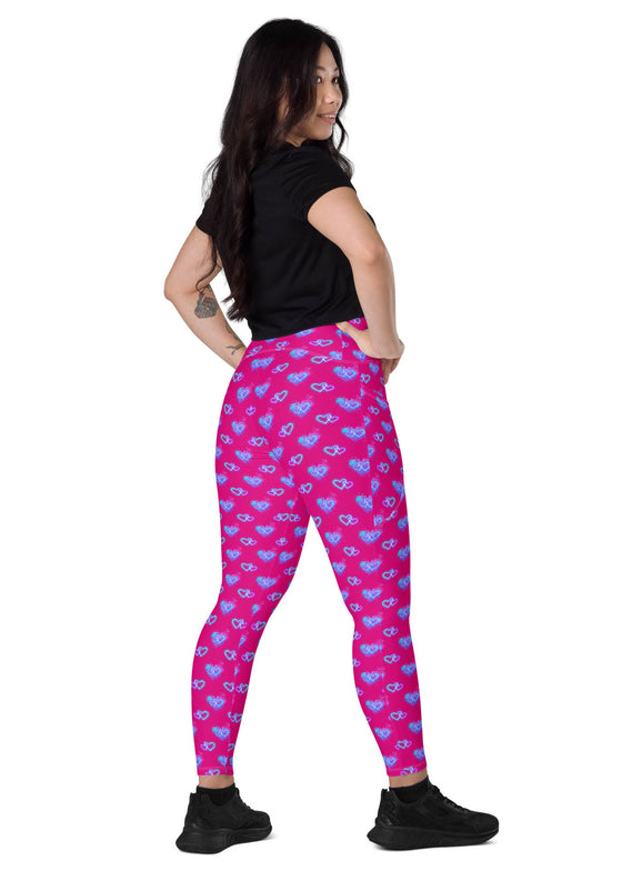 Side view of a woman standing in Vibrant Neon Heart violet-red high-waisted leggings with pockets. Stylish and functional gym leggings for women with a high-rise, compression fit and bold neon heart print.