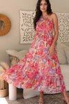Model showcasing the full front of the vibrant pink one shoulder maxi dress with cascading floral patterns and a flattering floor-length cut.

