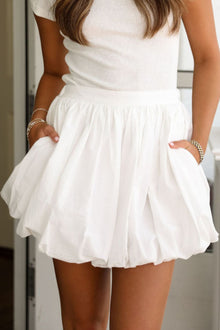   Front view of the White Bubble Mini Skirt with Pockets, showing the voluminous bubble silhouette and side pocket detailing.