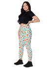 Model sitting in white floral high waisted leggings with pockets, showcasing comfort, style, and a secure waistband, ideal for both lounging and workouts.