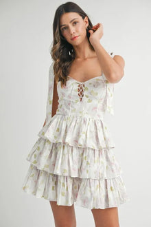  Model wearing a white floral layered mini dress in a full front view, highlighting the relaxed fit and playful tiered layers.