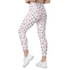 Model walking in white leggings with never ending hearts pattern. Gym-ready compression leggings for women with pockets and sculpting fit.
