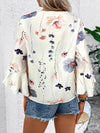 Back view of a white blouse with floral prints and relaxed fit, showing rear seam detail and hemline flow.