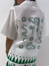 Back view of a white summer co-ord set with a buttoned shirt and flowy skirt, offering a soft silhouette ideal for casual outdoor settings.