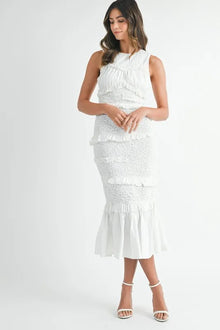  Full front view of the white smocked midi dress, highlighting its romantic square neckline, delicate ruffle trim, and feminine silhouette that flares below the waist.


