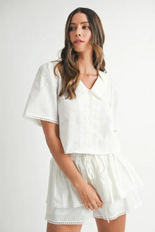   Front view showcasing a white tiered blouse paired with matching high-waisted shorts, creating a breezy and elegant summer outfit perfect for casual or vacation wear.