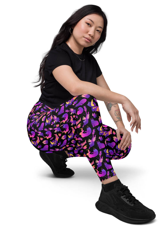 Side view of woman sitting in Witchy Kitties Printed Black high-waist leggings with pockets. Soft fabric and unique print with pockets for added convenience.