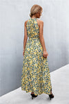Back view of yellow-green printed tie waist maxi dress showing the flowy silhouette and elegant long hem—relaxed vacation-ready fashion.