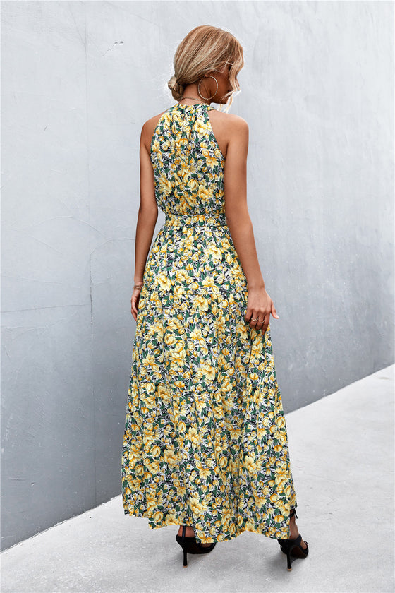 Back view of yellow-green printed tie waist maxi dress showing the flowy silhouette and elegant long hem—relaxed vacation-ready fashion.
