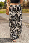 Front view of printed drawstring waist pants featuring a leaf print in black and white.